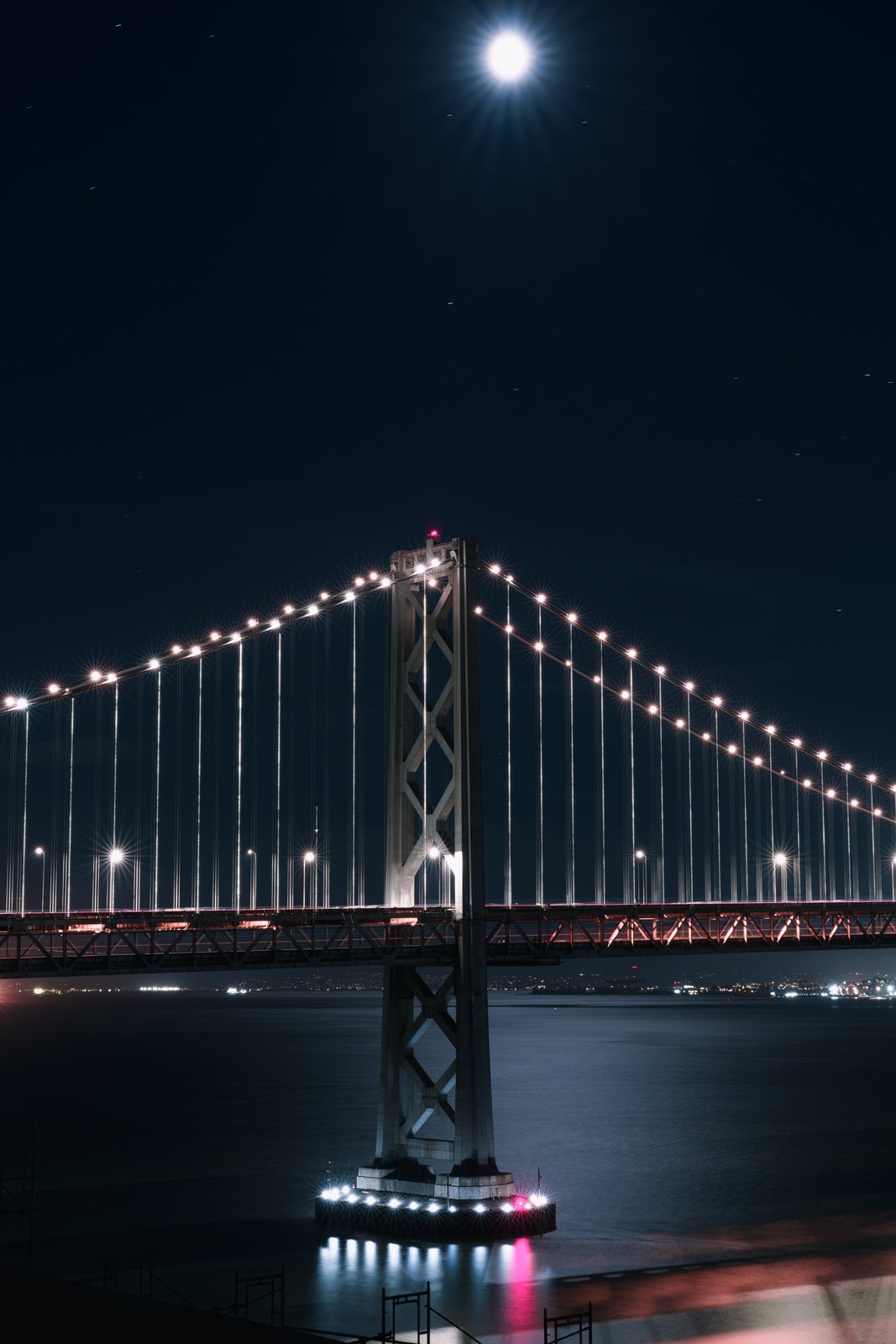 Bay Bridge tower at night under a full moon
