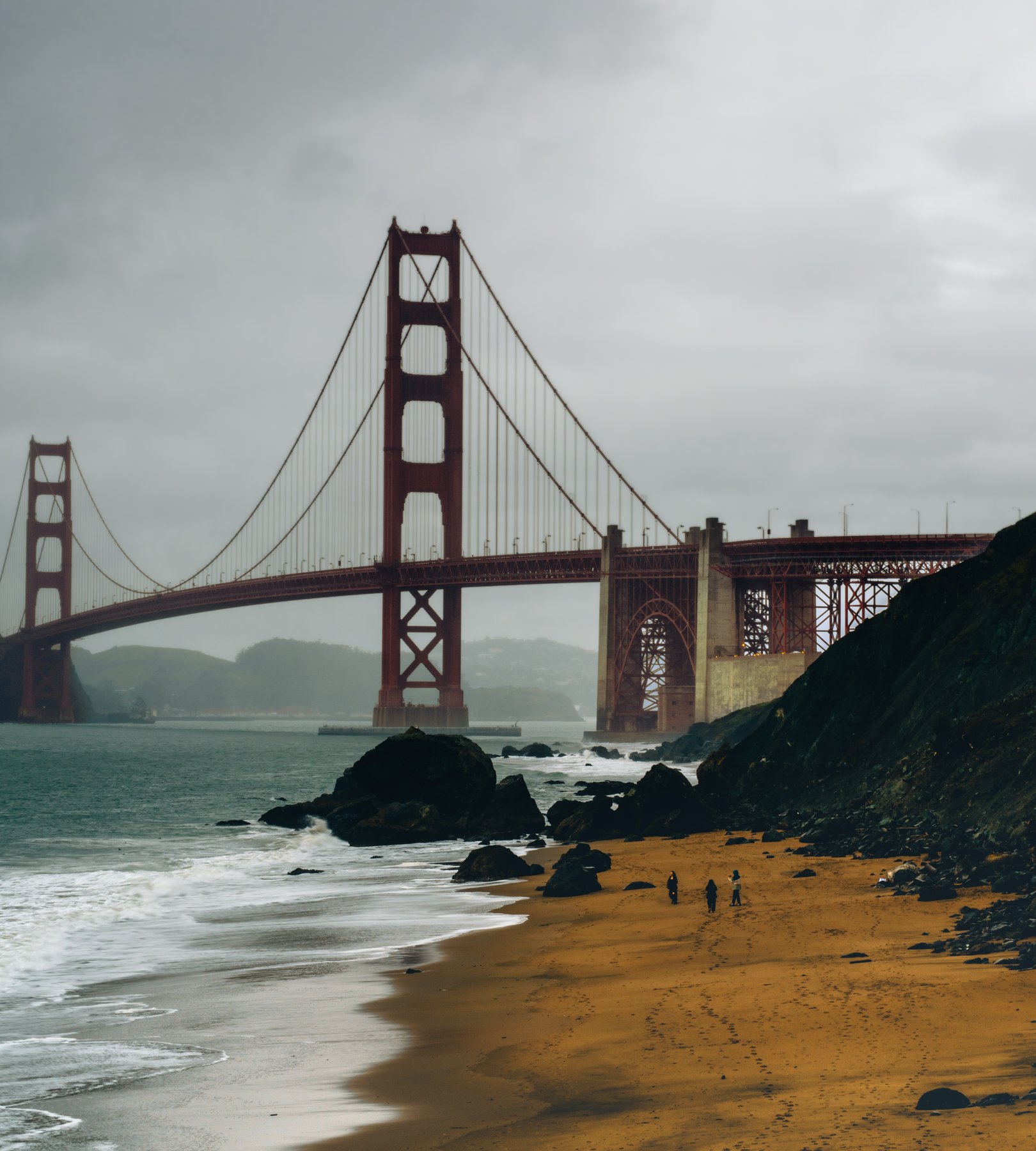 Golden Gate Bridge from Baker Beach under a dramatic stormy sky