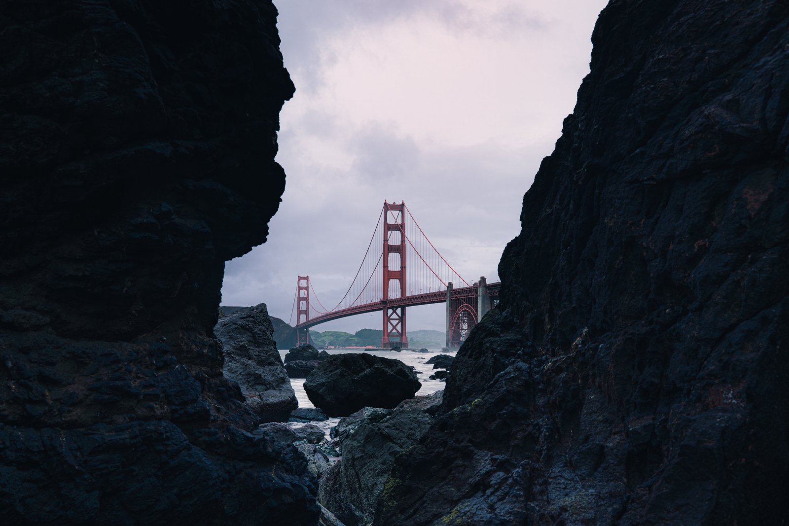 The Golden Gate Bridge framed between two dark rock formations