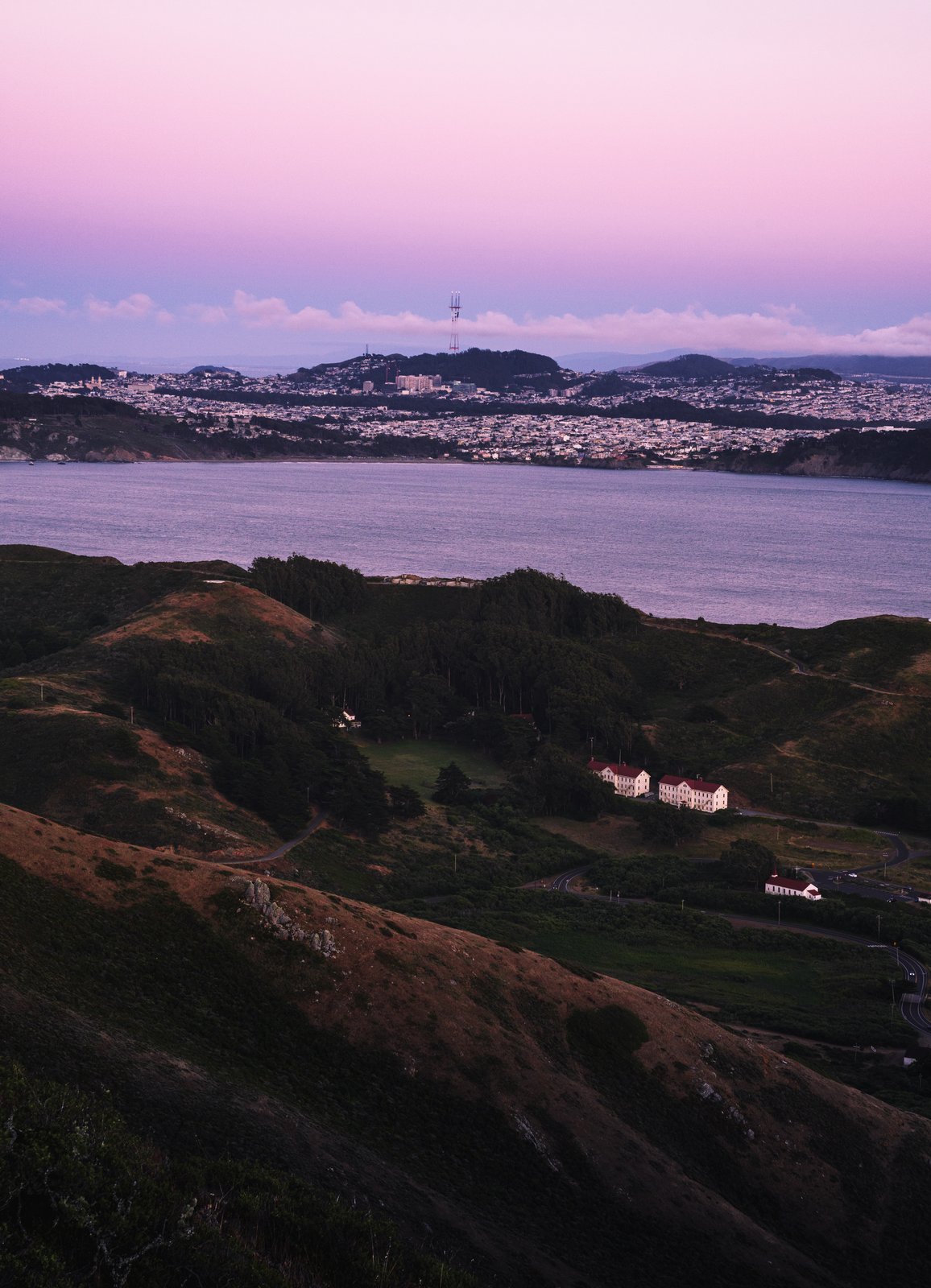 The bay and Marin hillside at dusk with a historic building below
