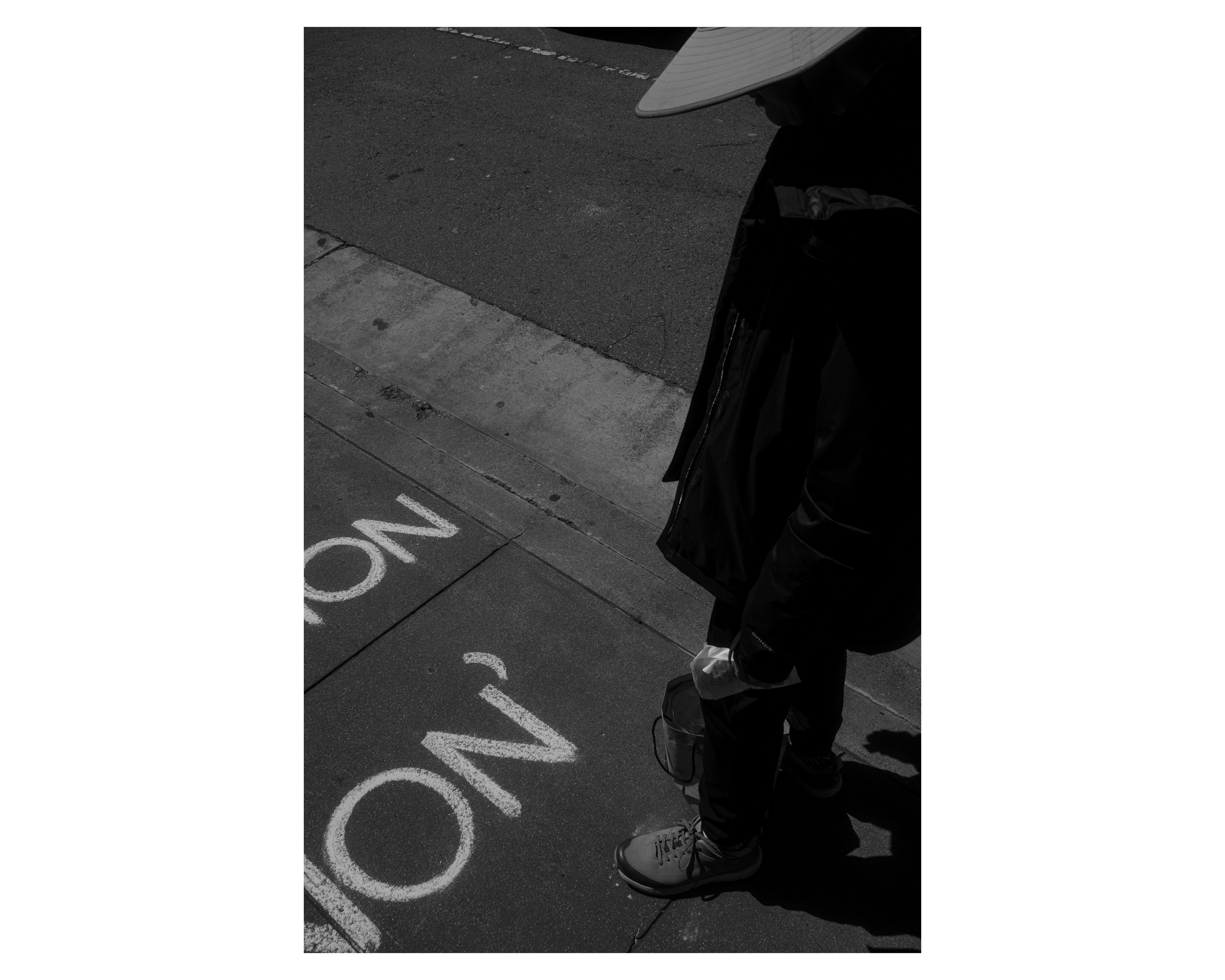 A bald man stepping down from a Muni bus, lit by a hard shaft of light
