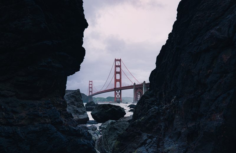 The Golden Gate Bridge framed between two dark rock formations