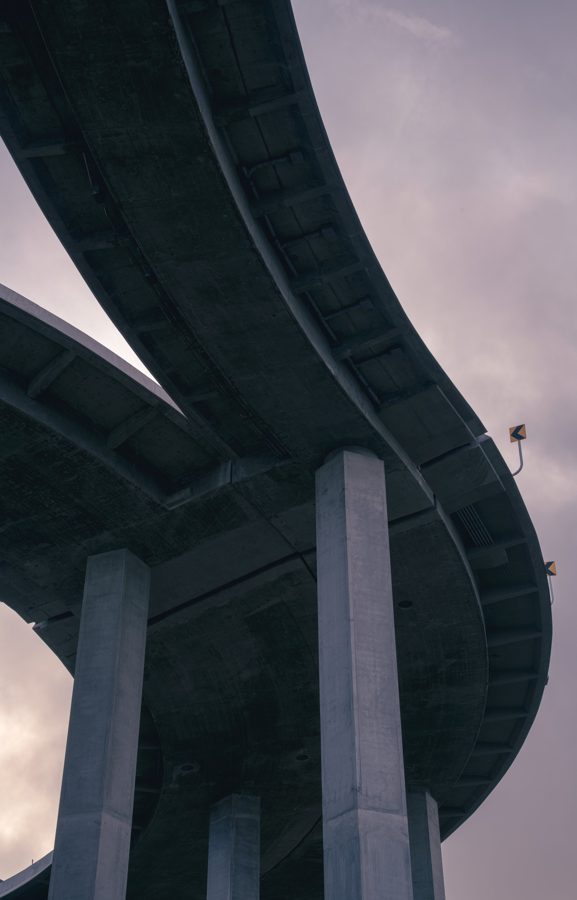 Looking straight up at the underside of a curving freeway overpass